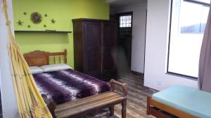 1 dormitorio con 1 cama y 1 hamaca en una habitación en Refúgio Gamboa en Garopaba