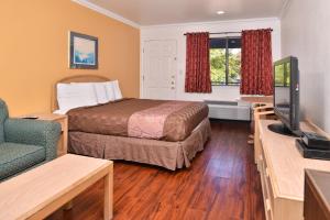 Habitación pequeña con cama y TV en Americas Best Value Inn and Suites Clearlake, en Clearlake