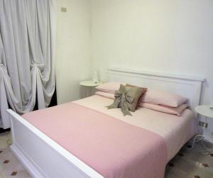 a bedroom with a bed with pink sheets and pillows at Zara Apartment in Treviso