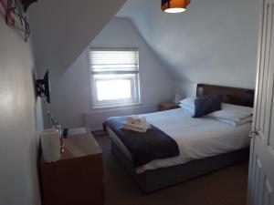 a small bedroom with a bed and a window at The Westby in Bournemouth
