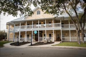 a large white house with a wrap around porch at Gruene River Hotel & Retreat in New Braunfels