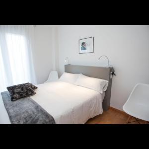 a bedroom with a large white bed and a window at Pis del Mercat -aire acondicionado en todas las habitaciones y salón- in Deltebre