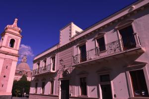 un edificio con una torre y un edificio con una torre de reloj en Palazzo Galifi, en Paterno