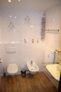 a white bathroom with a toilet and a sink at Ferienwohnung Gaffelschoner in Hohen Wieschendorf