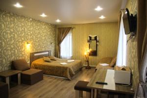 コストロマにあるLubas Apartment Monastery Viewのベッドとデスクが備わるホテルルームです。