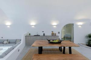 a living room with a table and a couch at Alluvial Santorini Suites in Mesaria