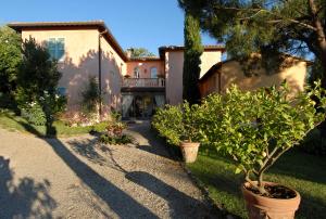 uma casa com uma árvore e algumas plantas num quintal em Il Rondò Boutique Hotel em Montepulciano