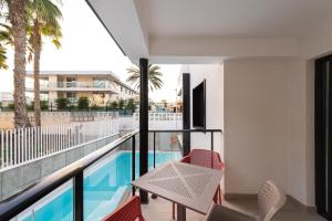 a balcony with a table and chairs and a swimming pool at B SLOW San Agustin Condor in San Agustin