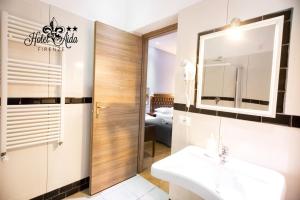 bagno con lavandino e specchio di Hotel Aida a Firenze