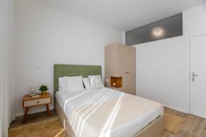 um quarto com uma grande cama branca e uma mesa em 2 Bedroom Cosy Flat em Porto