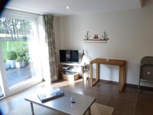 a living room with a large window and a television at La Florentine in Hardelot-Plage