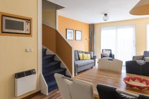 ein Wohnzimmer mit einem Esstisch und einer Treppe in der Unterkunft Appartement De Vrijbuiter, Resort Amelander Kaap in Hollum