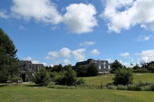 eine Gruppe von Gebäuden auf einem Feld mit blauem Himmel in der Unterkunft Appartement De Vrijbuiter, Resort Amelander Kaap in Hollum