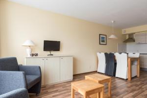 a living room with a couch and a tv at Appartement De Vrijbuiter, Resort Amelander Kaap in Hollum