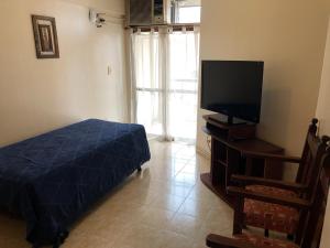 a bedroom with a bed and a flat screen tv at Catalina Norte in San Miguel de Tucumán