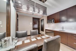 a kitchen with a wooden table and chairs and a counter at Jet Luxury at The Vdara in Las Vegas