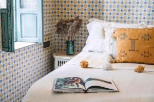 un libro sobre una cama con ventana en Riad BE Marrakech, en Marrakech