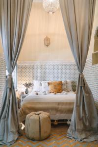 Riad BE Marrakech في مراكش: غرفة نوم بسرير مع ستائر وحقيبة