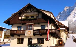 un edificio en las montañas con un cartel en Appartement Valentin, en Ehrwald