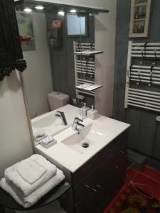 uma casa de banho com um lavatório branco e um espelho. em The Good Studio Vezelay em Vézelay