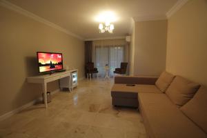 a living room with a couch and a flat screen tv at Alaçatı Çınar Boutique Hotel in Alaçatı