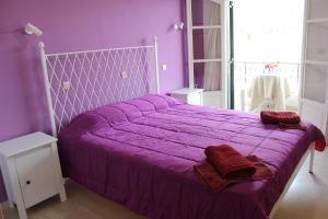 Natasa and Spiros في باليوكاستريتسا: غرفة نوم أرجوانية مع سرير كبير مع ملاءات أرجوانية