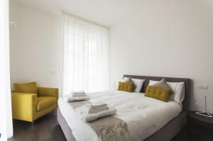 1 dormitorio con 1 cama y 1 silla amarilla en Design & New Center Apartments, en Milán