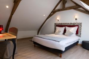 LompretにあるLa Ferme Blanche, The Originals Relaisのベッドルーム1室(ベッド1台、木製デスク付)