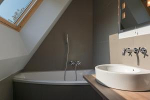 a bathroom with a sink and a bath tub at La Ferme Blanche, The Originals Relais (Relais du Silence) in Lompret