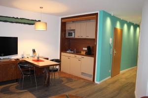 cocina con escritorio y mesa con sillas en I.M.Apartments 42 m² für 2 Personen, en Düsseldorf