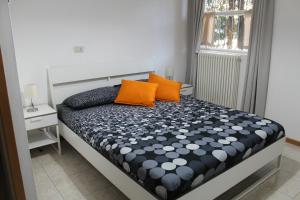 a bed with two orange pillows on it in a room at gli oleandri in Bellano