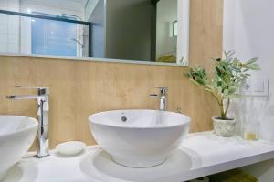 La salle de bains est pourvue d'un lavabo blanc et d'un miroir. dans l'établissement Paz Velvet, Espectacular Piso en Calle La Paz, à Valence