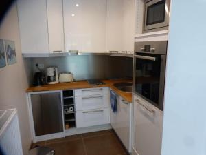 a small kitchen with white cabinets and a sink at La Florentine in Hardelot-Plage