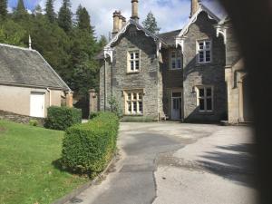 an old stone house with a driveway in front of it at The Lake Lodge, Wansfell Holme, Windermere in Ambleside