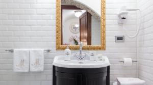 ein Bad mit einem Waschbecken und einem Spiegel in der Unterkunft M Empire in Rom