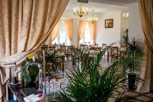 una sala da pranzo con tavoli, sedie e piante di Da Vinci a Chęciny