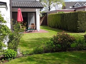 Ferienwohnung am Junkerbült في باد سفيشنآن: فناء بطاولة ومظلة في ساحة