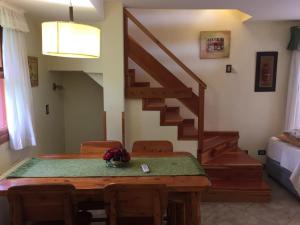 un comedor con una mesa de madera y una escalera en Bungalows Maniu, en San Carlos de Bariloche