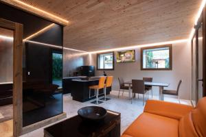 sala de estar con sofá naranja y mesa en Neuprantl Apartments, en Lana