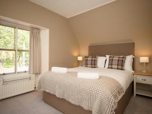 a bedroom with a large bed and a window at Ptarmigan in Aviemore