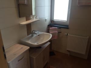 Ferienwohnung am Junkerbült في باد سفيشنآن: حمام مع حوض أبيض ونافذة +8 صور