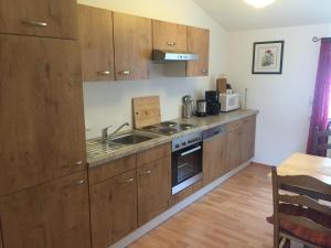 Ferienwohnung am Junkerbült في باد سفيشنآن: مطبخ مع خزائن خشبية ومغسلة