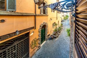 un callejón en un casco antiguo con puertas verdes en Karma House Deluxe Navona en Roma