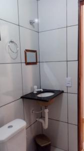 a bathroom with a toilet and a sink at Jangadas do Pontal in Fortim