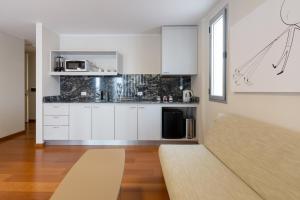 a kitchen with white cabinets and a couch in a room at B131 - Argentina in Córdoba