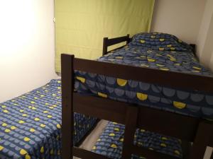 sypialnia z 2 łóżkami piętrowymi z niebieską i żółtą pościelą w obiekcie Apartamento la serena a pasos del mar w mieście La Serena