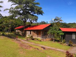 ein Haus mit einem roten Dach und einem Hof in der Unterkunft Hotel Rincón de la Vieja Lodge in Liberia