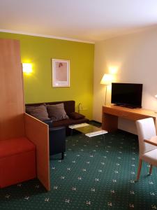 a hotel room with a couch and a television at Hotel Kreuzwirt in Engerwitzdorf