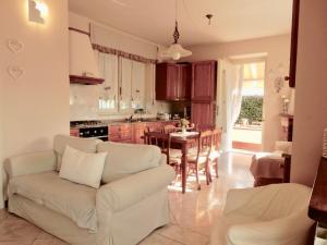 een woonkamer met een witte bank en een keuken bij Villa La Palma in Camaiore