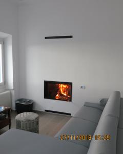 a living room with a couch and a fireplace at Andoni's House in Pitrofós